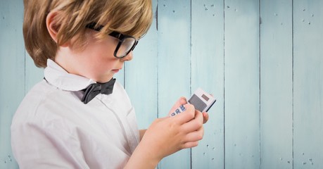 Canvas Print - Boy with calculator against blue wood panel