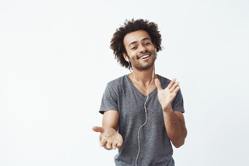 Wall Mural - Cheerful african man listening to music in headphones dancing singing.