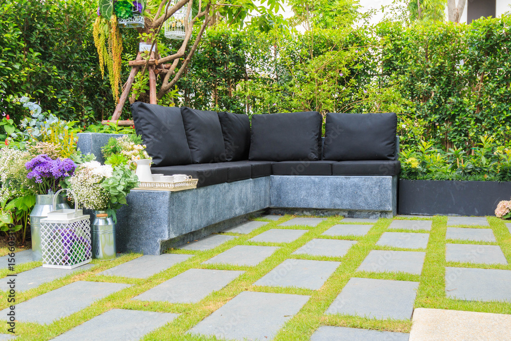 Tea set on a stone bench in a flower garden. Stock Photo | Adobe Stock
