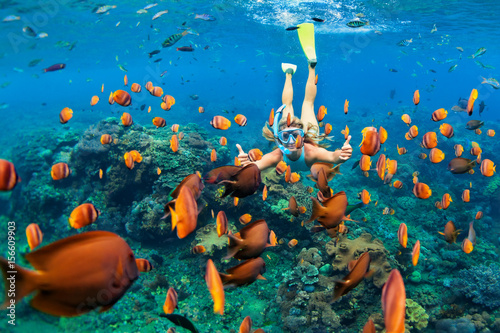 Fotomural Happy family - girl in snorkeling mask dive underwater with tropical fishes in coral reef sea pool