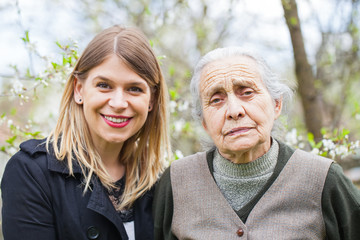 Canvas Print - Happy elderly woman with carer outdoor - springtime