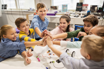 Wall Mural - happy children making high five at robotics school
