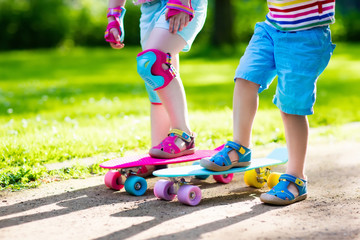 Wall Mural - Children riding skateboard in summer park