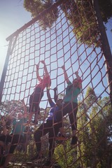 Wall Mural - Group of fit woman climbing a net during course