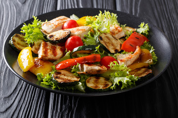 Wall Mural - Grilled chicken breast and summer vegetables close-up on a plate. horizontal