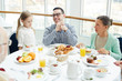 © pressmaster - Young man, his daughter and mature woman sitting by served table