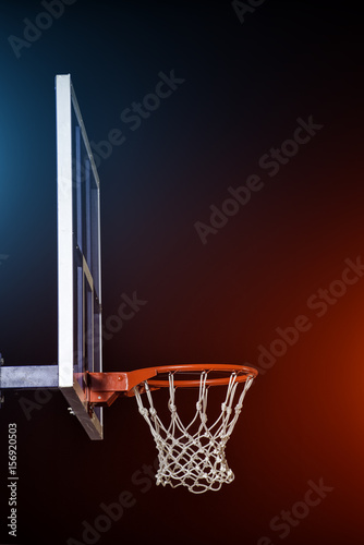 Plakat Obręcz do koszykówki na białym tle na czarno. Rozjaśnione przez mieszane kolorowe światła.