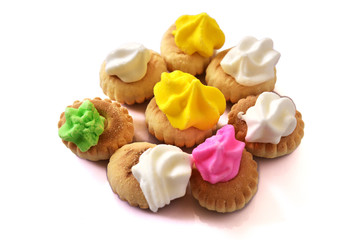 Handful of iced gem biscuits on white background.