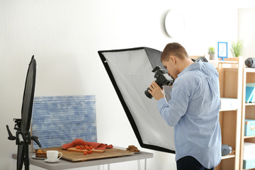 Wall Mural - Young man photographing food in professional photo studio