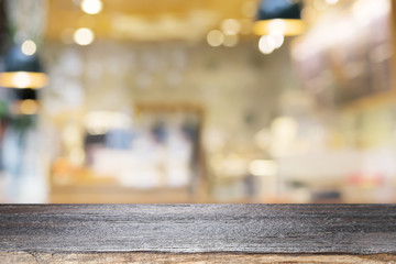 Wall Mural - Empty wooden table for present product on coffee shop or soft drink bar blur background with bokeh image