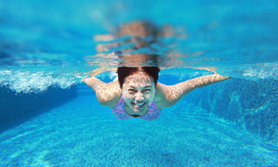 Underwater woman portrait in swimming pool.