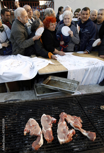 People wait to be served with steaks at Athens' meat market ...