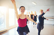 Cheerful multiracial adult ballerinas group with hands up