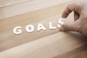 Wall Mural - Goals word with male hand on wood table.Business marketing,analysis concept