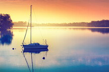 Little Sailing Boat Reflects In  The Serene Water During Sunrise. Masuria, Poland.