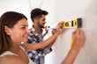 © didesign - Lovely young couple with tape measure, renovation concept