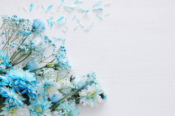 beautiful and delicate blue flowers arrangement on white wooden background