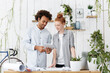 © wayhome.studio  - Portrait of two creative workers making blueprints together. Attractive male with wavy hair holding tablet showing his ginger colleague new project. Pleased coworkers isolated over workspace