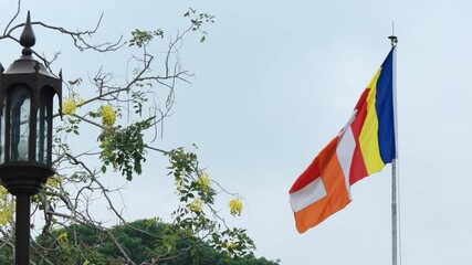 Wall Mural - Buddhist Flag Flapping from its Pole in Sri Lanka