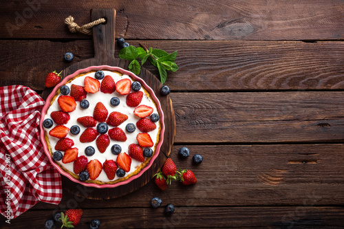 Fotografia, Obraz Delicious strawberry pie with fresh blueberry and whipped cream on wooden rustic