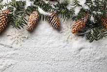 Snowy Christmas Background With Fir Branch And Pine Cones.