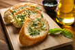 © Africa Studio - Tasty bread with garlic, cheese and herbs on kitchen table, close up