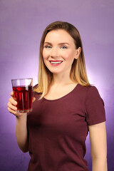 Poster - Beautiful woman with glass of fresh juice on color background