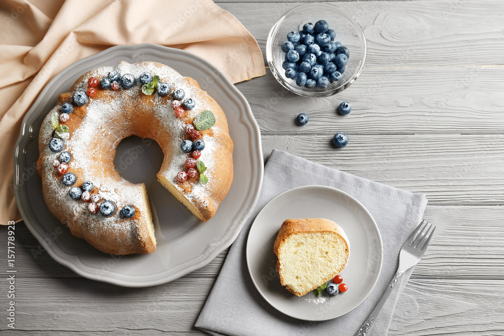 Plate with delicious yogurt cake, berries and mint on wooden table