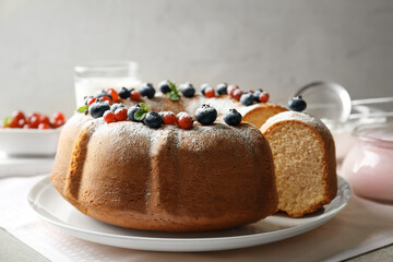 Wall Mural - White plate with sliced yogurt cake and berries on grey background