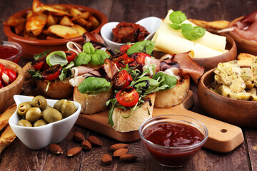 Italian antipasti wine snacks set. Cheese variety, Mediterranean olives, pickles, Prosciutto di Parma, tomatoes, artichokes and wine in glasses