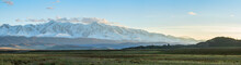 Panoramic View Of Snow-capped Mongolian Prairie With Cloudy Sky On Background
