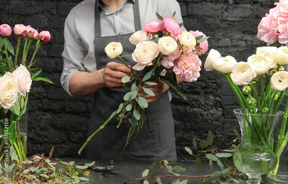 Male florist creating beautiful bouquet in flower shop, close up - obrazy, fototapety, plakaty 