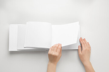 Sticker - Female hands holding book with blank pages on white background