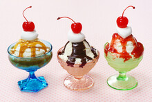 Three Ice Cream Sundaes With Whipped Cream And Cherries