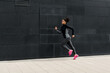 © Artem Varnitsin - Side view of female athlete running near a wall