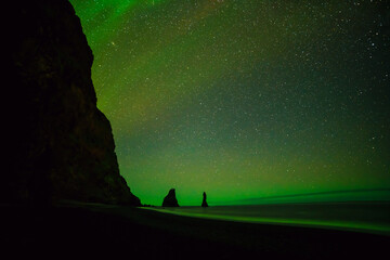 northern lights above black sand beach in vik