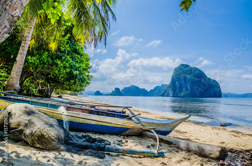 Fishing Boat And Net On Shore Under Palms Tropical Island Landscape El Nido Fishing Boat And Net On Shore Under Palms Tropical Island Landscape El Nido