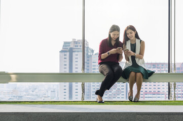 Two asian Businesswomen using the smart phone In the modern creative Office, business success concept