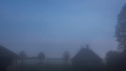 Wall Mural - Night timelapse of misty fog blowing over building  at dusk. Night sky with stars.