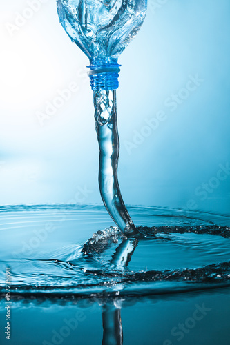 przeplyw-wody-z-plastikowej-butelki-na-niebieskim-tle