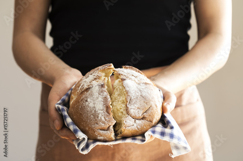 Plakat Żeńska ręka trzyma gorącego świeżo piec chleb