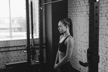 Wall Mural - attractive sportswoman standing in sports center, black and white