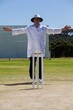 Full length of cricket umpire signalling wide ball during match