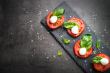 Fototapeta Mapy - Traditional italian caprese salad on black/ Top view.