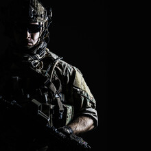 Elite Member Of US Army Rangers In Combat Helmet And Dark Glasses. Studio Shot, Dark Black Background, Looking At Camera, Dark Contrast