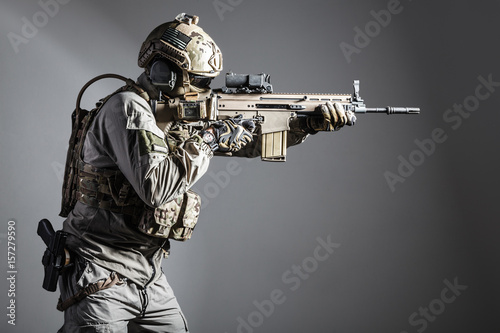 Plakat Żołnierz armii w mundurze ochronnym, posiadający karabiny szturmowe Special Operations Forces Combat. Strzelanie z broni z bliska. Studio strzał, odizolowywający na białym tle
