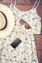 Wall Mural - Casual female dress with floral pattern, straw hat and smart phone