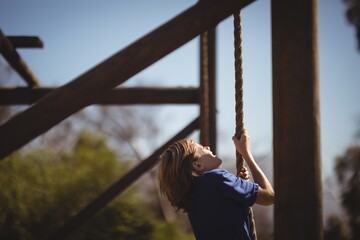Wall Mural - determined girl climbing rope during obstacle course