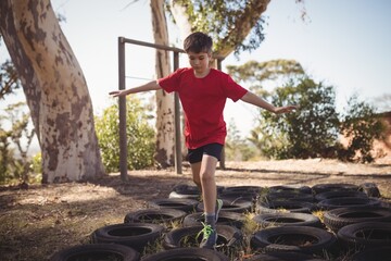 Wall Mural - boy running over tires during obstacle course