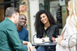 © javiindy - Multiracial group of four friends having a coffee together